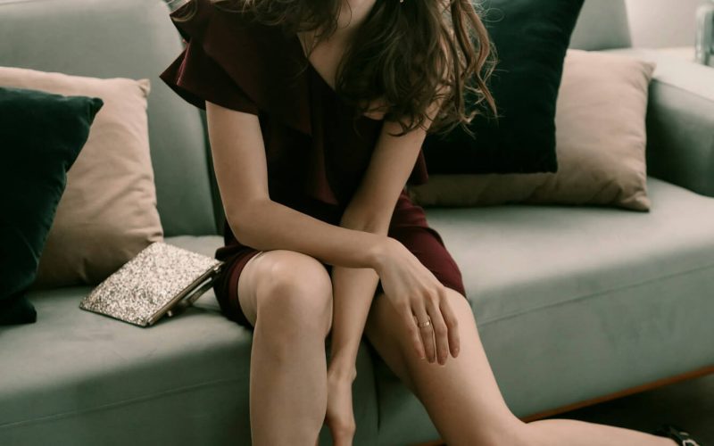 fancy-young-lady-in-a-cocktail-dress-and-high-heels-on-the-green-coach.jpg